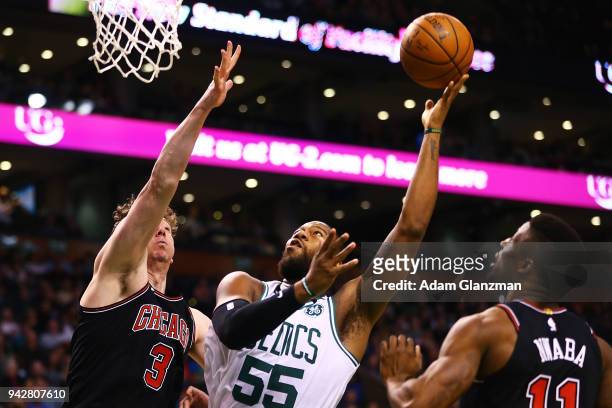 Greg Monroe of the Boston Celtics shoots the ball over Omer Asik of the Chicago Bulls during a game at TD Garden on April 6, 2018 in Boston,...
