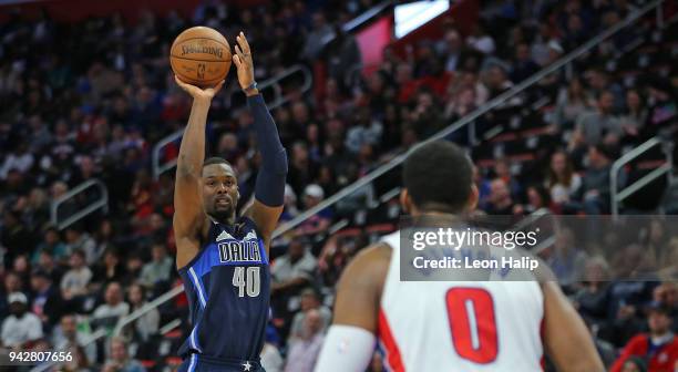 Harrison Barnes of the Dallas Mavericks shoots a three point shot as Andre Drummond of the Detroit Pistons looks on during the fourth quarter of the...