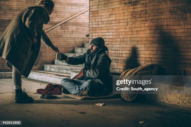 woman giving money to homeless - homeless winter stock pictures, royalty-free photos & images