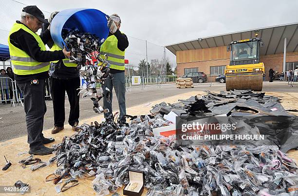 Costums officers prepare counterfeit sunglasses are destroyed on December 11, 2009 in Godewaersvelde, northern France, during the destruction of...