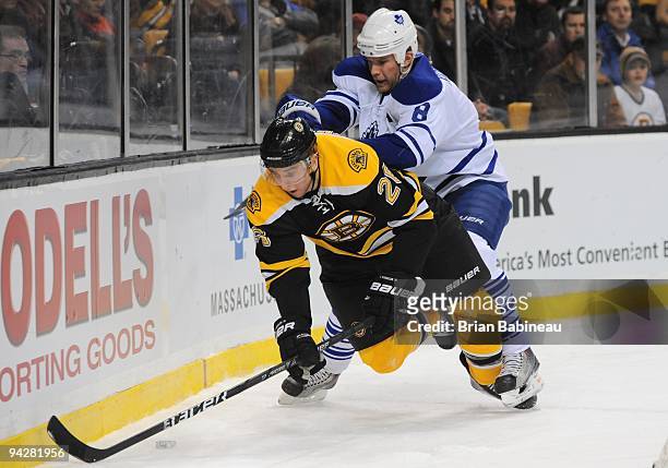 Mike Komisarek of the Toronto Maple Leafs checks against Blake Wheeler of the Boston Bruins at the TD Garden on December 10, 2009 in Boston,...