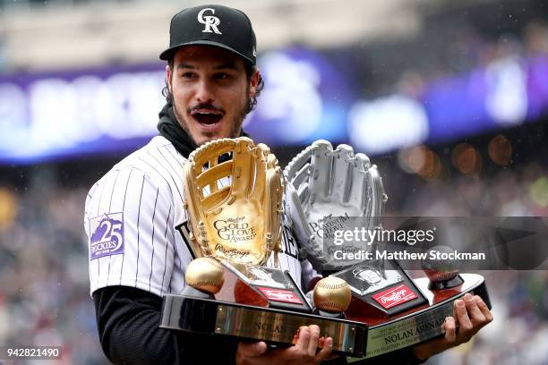 Nolan Arenado of the Colorado Rockies receives the Rawlings Gold Glove and Platinum Glove Award before the Rockies home opener against the Atlanta...