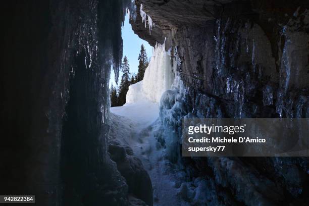 in a cave through the frozen tännforsen waterfall - jamtland stock pictures, royalty-free photos & images