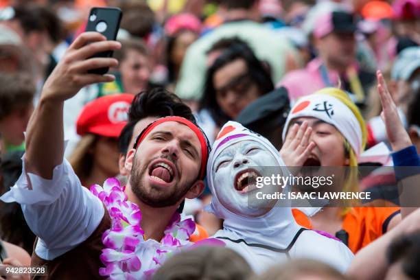 Fans dressed up in costumes pack the South Stand of Hong Kong Stadium early on the second day of the Hong Kong Sevens rugby tournament on April 7,...