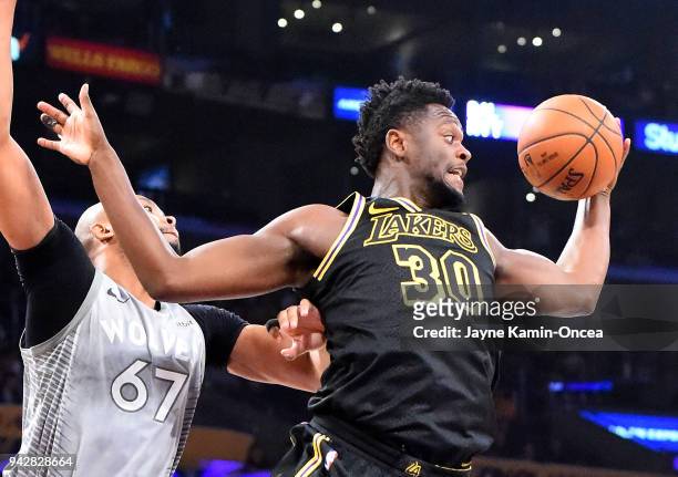 Julius Randle of the Los Angeles Lakers grabs a rebound in front of Taj Gibson of the Minnesota Timberwolves in the first half of the game at Staples...