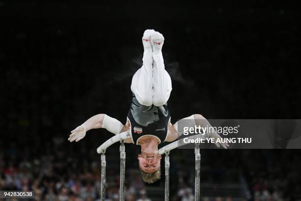 Nile Wilson of England competes on the parallel bars during the men's individual all-around final in the artistic gymnastics event during the 2018...