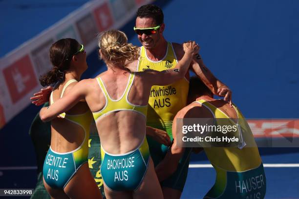 Jacob Birtwhistle of Australia celebrates with team mates Matthew Hauser, Gillian Backhouse and Ashleigh Gentle after winning Gold in the Triathlon...