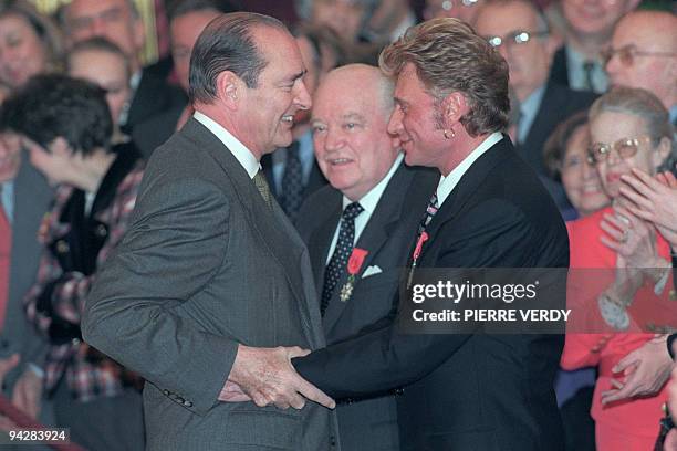 Le chanteur de rock et acteur français, Johnny Hallyday donne l'accolade au président de la République Jacques Chirac le 24 janvier 1997 à Paris au...