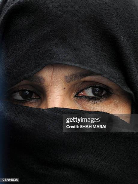 An Afghan woman covers her face during a demonstration in Kabul on December 10, 2009. Around 300 people protested on December 10 marching to the...