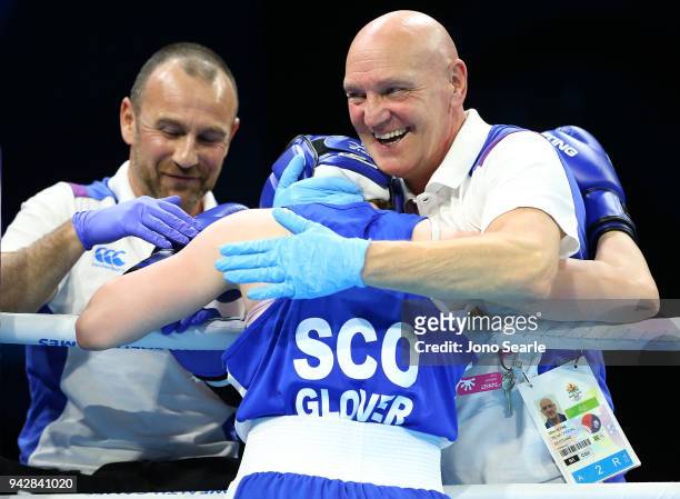 Vikki Glover of Scotland is congratulated by coach Mike Keane after beating Valerian Spicer of Dominica in the round of 16 bout on day three of the...