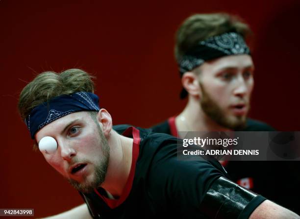 Canada's Marko Medjugoracz serves alongside partner Antoine Bernadet during the mens team quarter-final table tennis match against Singapore during...