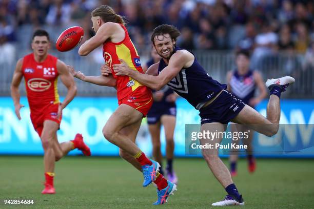 Joel Hamling of the Dockers tackles Aaron Young of the Suns during the round three AFL match between the Gold Coast Suns and the Fremantle Dockers at...
