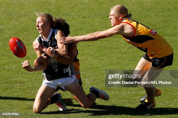 Jacob Lohmann of the Rebels handpasses the ball whilst being tackled during the round three TAC Cup match between Dandenong Stingrays and Greater...