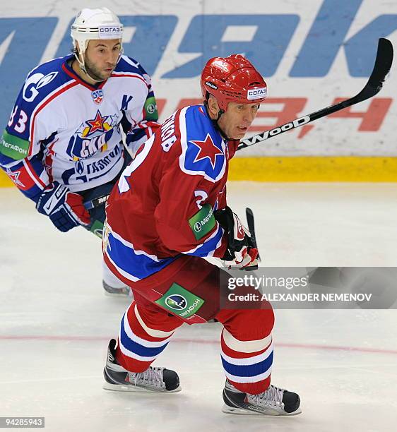 Famous Soviet, former NHL Detroit Red Wings' defender Viacheslav Fetisov of CSKA vies with Maxim Sushinsky of SKA St.Petersburg during their regular...