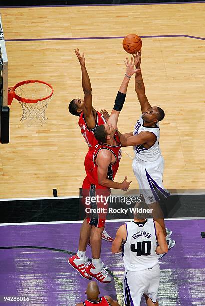 Kenny Thomas of the Sacramento Kings hooks a shot over Sean Williams and Brook Lopez of the New Jersey Nets during the game on November 27, 2009 at...