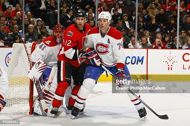 Defenseman Hal Gill of the Montreal Canadiens defends the crease area as Mike Fisher of the Ottawa Senators sets a screen in front of goaltender...