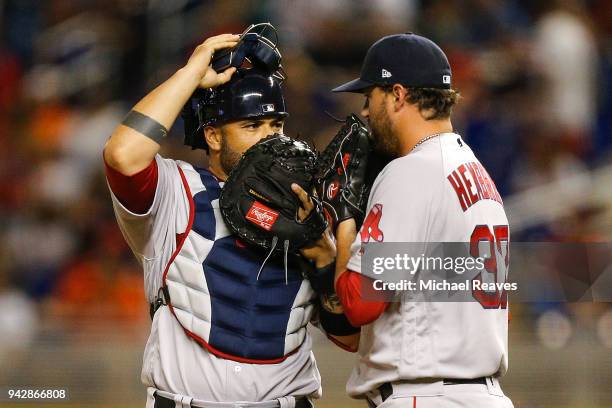 Heath Hembree of the Boston Red Sox talks with Christian Vazquez during the game against the Miami Marlins at Marlins Park on April 3, 2018 in Miami,...