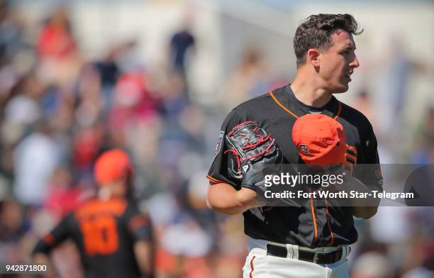 San Francisco Giants pitcher Derek Holland takes the mound against the Texas Rangers during spring training at Scottsdale Stadium in Scottsdale,...