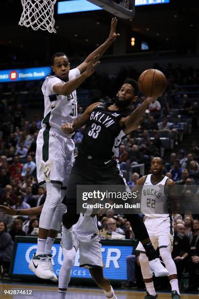 Allen Crabbe of the Brooklyn Nets passes the ball while being guarded by John Henson of the Milwaukee Bucks in the first quarter at the Bradley...