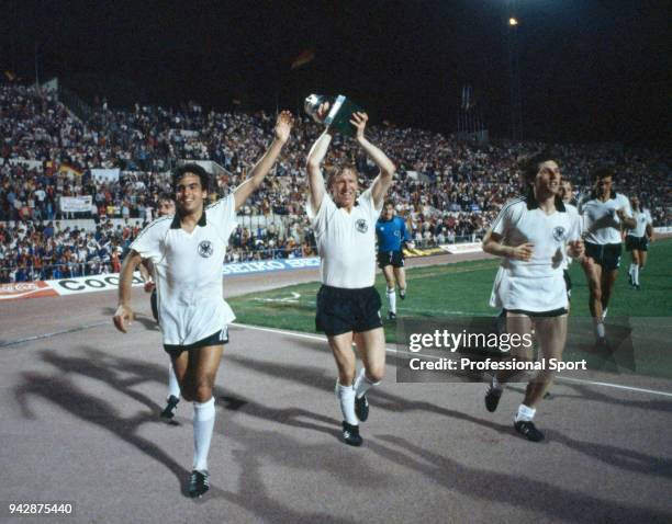 Horst Hrubesch of West Germany takes the trophy on a lap of honour with Hansi Muller and Manfred Kaltz alongside him after the UEFA Euro 1980 Final...