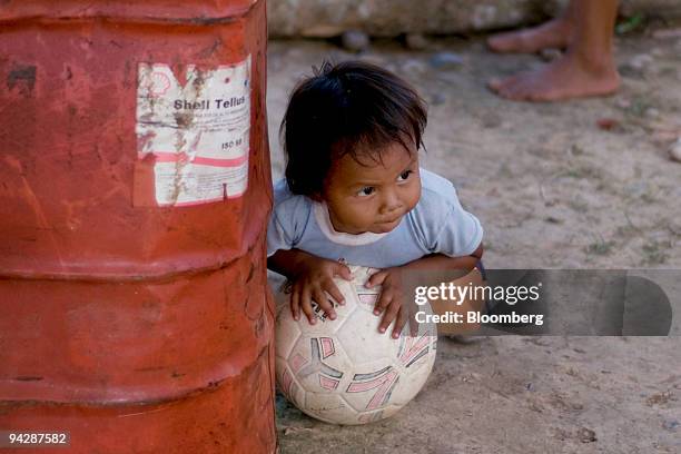 Child from the Huaorani tribe, also known as the Waos, who are native Amerindians from the Amazonian Region of Ecuador, plays near a discarded Shell...