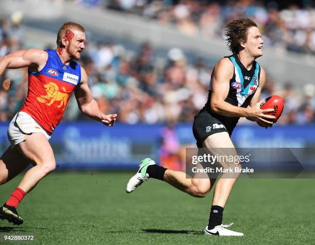 Jared Polec of Port Adelaide gets away from a bleeding Nick Robertson of the Lions during the round three AFL match between the Port Adelaide Power...