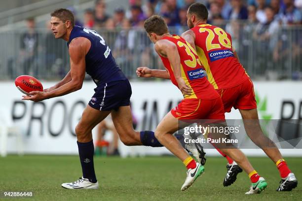 Aaron Sandilands of the Dockers handballs during the round three AFL match between the Gold Coast Suns and the Fremantle Dockers at Optus Stadium on...