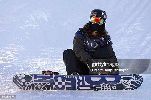 Shaun White of the USA straps on his board during practice for the US Snowboarding Grand Prix Men's Qualifier on the Main Vein Half Pipe on December...