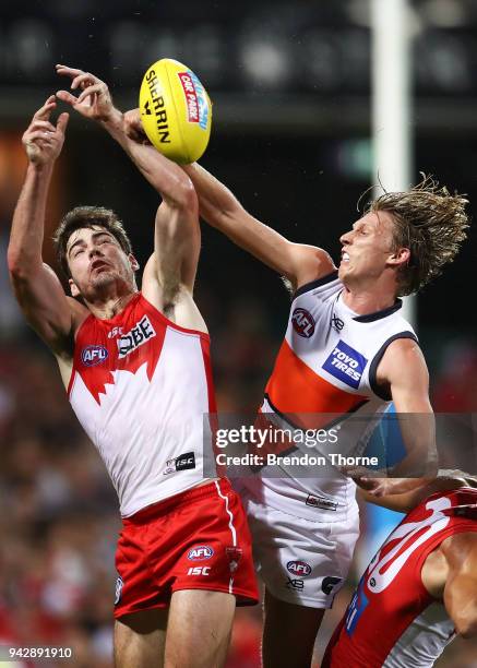 George Hewett of the Swans contests the ball with Lachie Whitfield of the Giants during the round three AFL match between the Sydney Swans and the...
