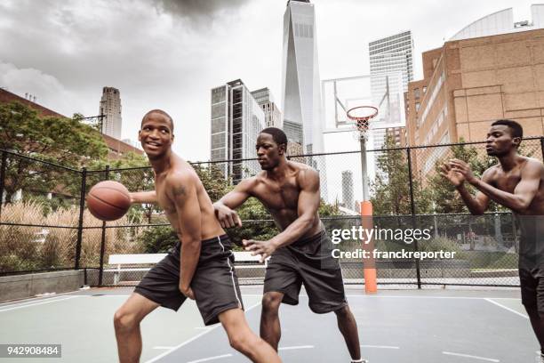 friends playing street basketball in nyc - street games stock pictures, royalty-free photos & images