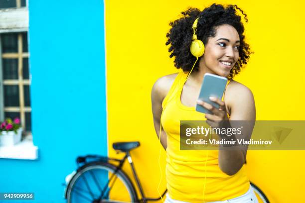 smiling woman with bike using smart phone - basket universitario imagens e fotografias de stock