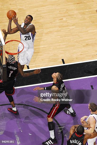 Donte Greene of the Sacramento Kings goes up for a shot against Dorell Wright and Michael Beasley of the Miami Heat during the game at Arco Arena on...