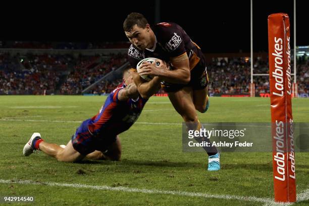 Corey Oates of the Broncos scores a try tackled by Shaun Kenny-Dowall of the Knights during the round five NRL match between the Newcastle Knights...