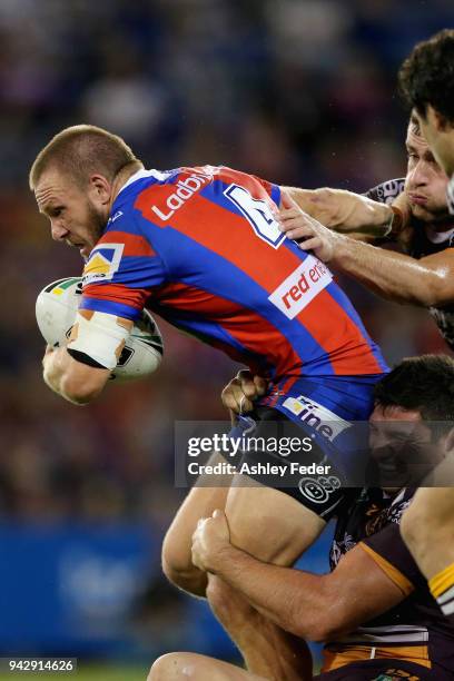 Nathan Ross of the Knights is tackled by the Broncos defence during the round five NRL match between the Newcastle Knights and the Brisbane Broncos...