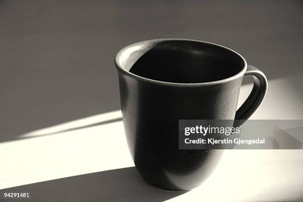 drinking mug on table in low sunlight - black mug stock pictures, royalty-free photos & images