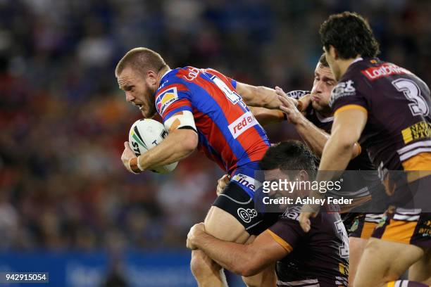Nathan Ross of the Knights is tackled by the Broncos defence during the round five NRL match between the Newcastle Knights and the Brisbane Broncos...