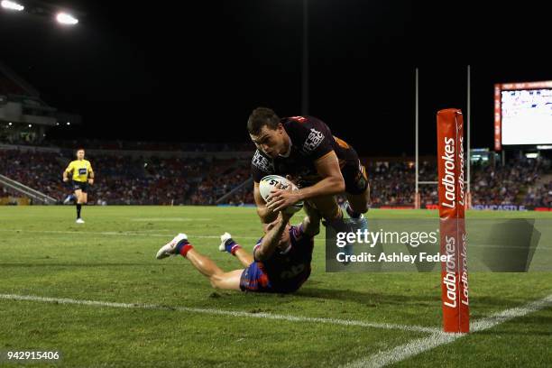 Corey Oates of the Broncos scores a try tackled by Shaun Kenny-Dowall of the Knights during the round five NRL match between the Newcastle Knights...