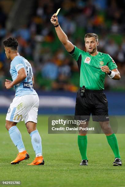 The referee shows Daniel Arzani of Melbourne City a yellow card during the round 26 A-League match between Melbourne City and the Central Coast...