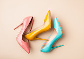 Set of colored women's shoes on beige background