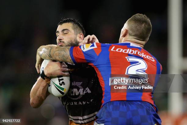 Jack Bird of the Broncos is tackled by the Knights defence during the round five NRL match between the Newcastle Knights and the Brisbane Broncos at...