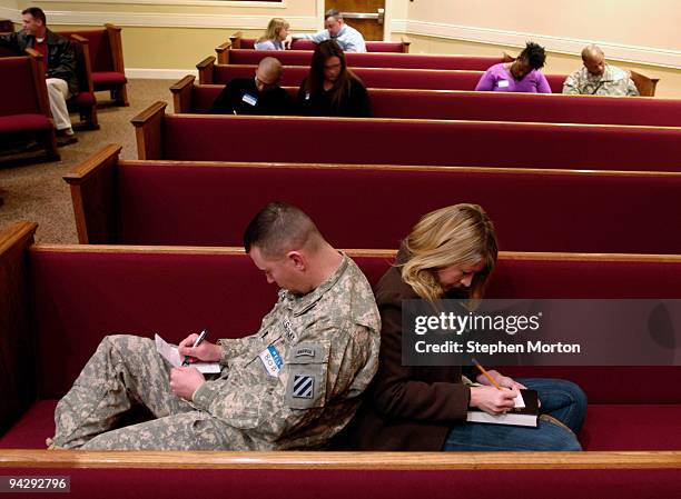 Army 1st Heavy Brigade Combat Team Captain Bob Kolb and his wife Lisa Kolb fill out commitment cards as part of the Coin and Covenant Ceremony...