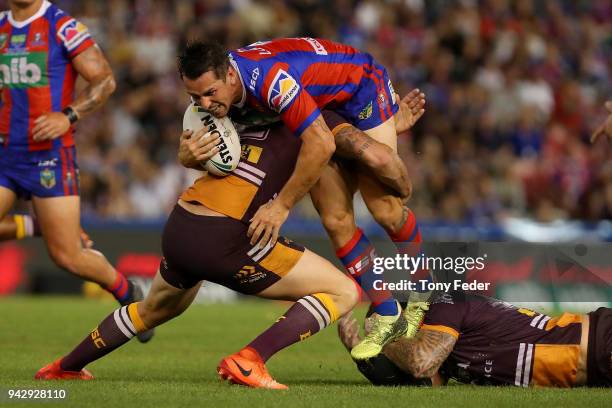 Mitchell Pearce of the Knights is tackled during the round five NRL match between the Newcastle Knights and the Brisbane Broncos at McDonald Jones...