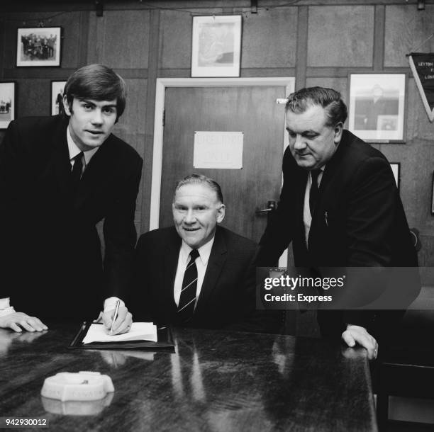 British soccer player Peter Collins signs transfer forms from Chelmsford City FC to Tottenham Hotspur FC, with respective managers Harry Ferrier and...