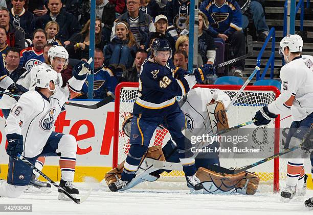 David Backes of the St. Louis Blues swings at the puck as Ryan Potulny Ladislav Smid and Jeff Deslauriers of the Edmonton Oilers defend on December...
