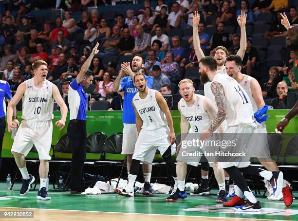 The Scotland bench celebrate after Gareth Murray of Scotland scores a three point shot during the Preliminary Basketball round match between Scotland...