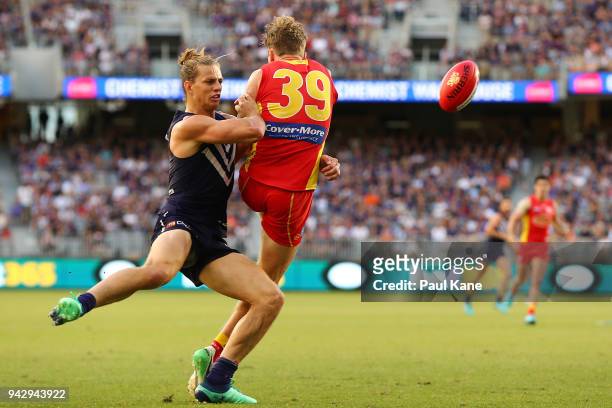 Nathan Fyfe of the Dockers tackles Nick Holman of the Suns during the round three AFL match between the Gold Coast Suns and the Fremantle Dockers at...