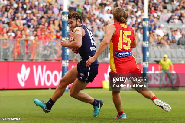 Connor Blakely of the Dockers gathers the ball against Aaron Young of the Suns during the round three AFL match between the Gold Coast Suns and the...