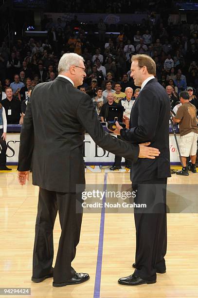 Head coach Phil Jackson of the Los Angeles Lakers congratulates head coach Kurt Rambis of the Minnesota Timberwolves after Rambis was presented his...