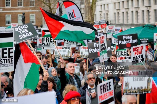 Protesters shout slogans and hold placards and Palestianian flags during a demonstration on Whitehall opposite Downing Street in central London on...