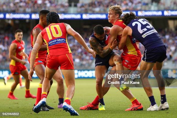 Tom Lynch of the Suns gets tackled by Michael Walters and Alex Pearce of the Dockers during the round three AFL match between the Gold Coast Suns and...